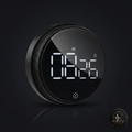 A round black digital alarm clock with a glossy glass face and white LED display showing 08:26, set against a dark reflective background.